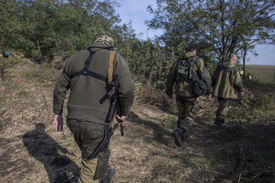 An American who calls himself "Hunter" walks in a field with his fellow rebels near the town of Yasynuvata